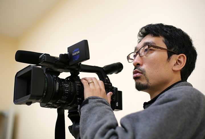 カメラを構える木田修作さん。自主避難者の住宅提供打ち切りをめぐる国の関与を明らかにするスクープ等により、日隅一雄・情報流通促進賞の特別賞を受賞した