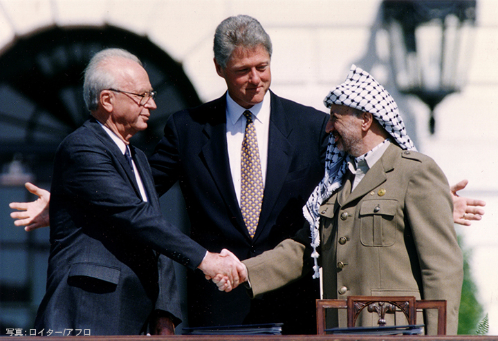 PLO Chairman Yasser Arafat (R) shake hands with Israeli Prime Minister Yitzhak Rabin (L), as U.S. President Bill Clinton stands between them, after the signing of the Israeli-PLO peace accord, at the White House in Washington, U.S., September 13, 1993. REUTERS/Gary Hershorn/File Photo (United States)